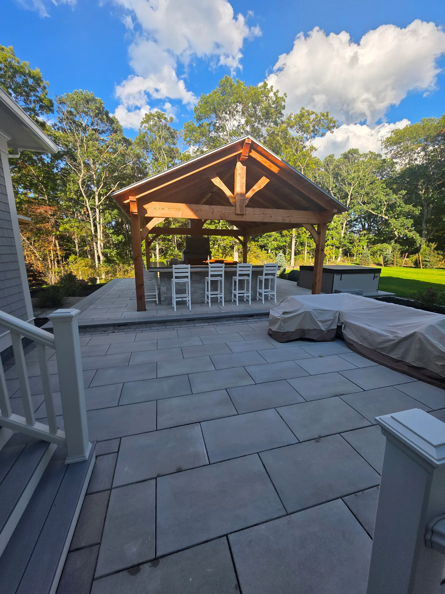 Timber pavilion and outdoor bar above a finished stone terrace