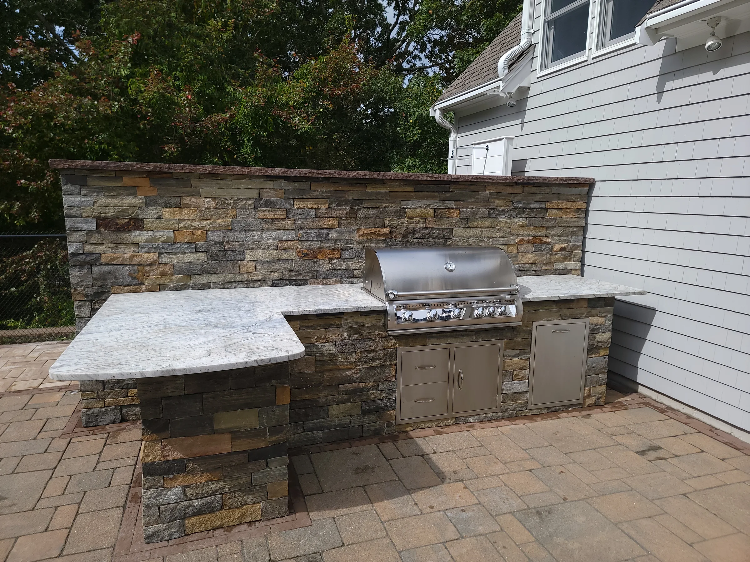 Outdoor kitchen built into a stone wall with broad counters